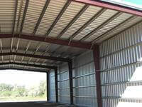 Secondary framing of a 50' x 100' x 20' open ended custom kit building erected on 18 inch x 10' x 36 inch baled piers.